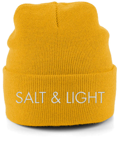 Close-up of a mustard yellow cuffed beanie featuring high-quality white embroidery of the words 'SALT & LIGHT' in a modern, bold font
