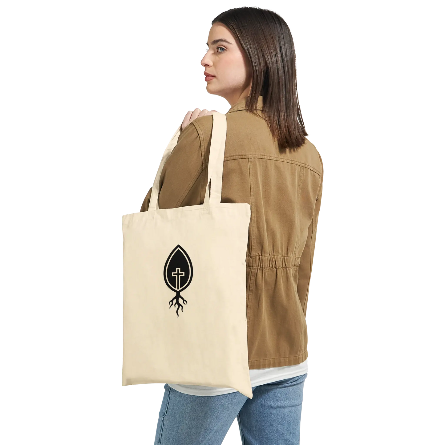 Woman holding natural canvas tote bag with black Christian cross and root logo
